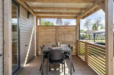 a screened porch with a table and chairs on it at Camping Papillon Kinrooi - La Casetta in Kinrooi