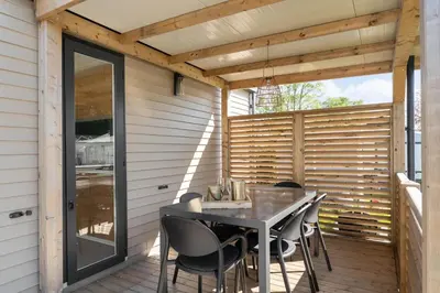 a patio with a table and chairs on a deck at Camping Papillon Kinrooi - La Casetta in Kinrooi