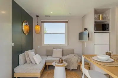 a living room with a couch and a table at Camping Papillon Kinrooi - La Casetta in Kinrooi