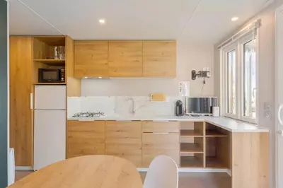 a kitchen with wooden cabinets and a white refrigerator at Camping Papillon Kinrooi - Vakantiehuis Premium 4P in Kinrooi