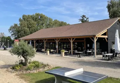 a pavilion with a table in front of a building at Camping Papillon Kinrooi - Vakantiehuis Premium 4P in Kinrooi