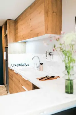 a kitchen with wooden cabinets and a white counter top at Camping Papillon Kinrooi - Vakantiehuis Premium 4P in Kinrooi