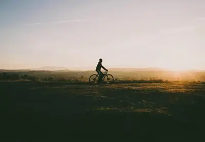 a person riding a bike on a field at sunset at Camping Papillon Kinrooi - Vakantiehuis Premium 4P in Kinrooi