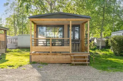 a wooden gazebo with a table and chairs at Camping Papillon Kinrooi - Vakantiehuis Premium 4P in Kinrooi