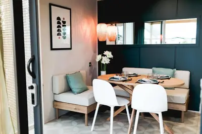 a dining room with a table and white chairs at Camping Papillon Kinrooi - Vakantiehuis Premium 4P in Kinrooi