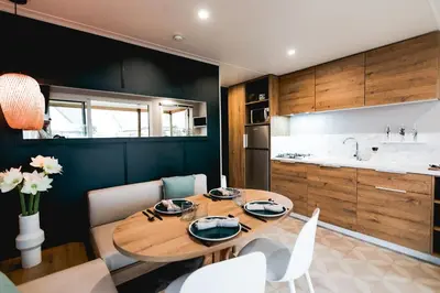 a kitchen and dining room with a wooden table and chairs at Camping Papillon Kinrooi - Vakantiehuis Premium 4P in Kinrooi