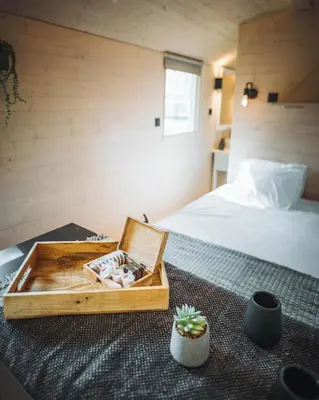 a bedroom with a bed and a wooden box on the floor at Camping Papillon Kinrooi - Pipowagen 2p terras in Kinrooi