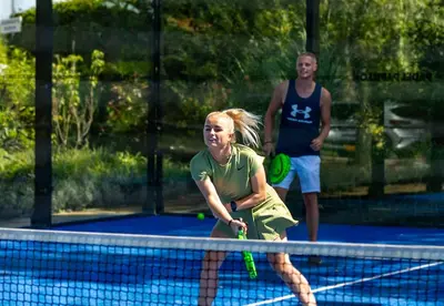 a woman holding a tennis racket on a tennis court at Camping Papillon Kinrooi - Pipowagen 2p terras in Kinrooi