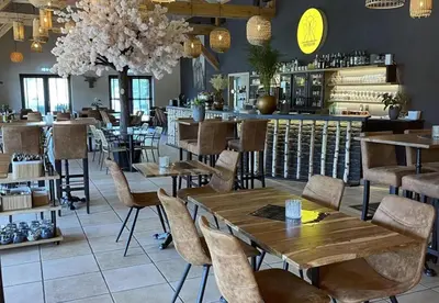 a restaurant with tables and chairs and a bar at Camping Papillon Kinrooi - Pipowagen 2p terras in Kinrooi