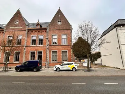 two cars parked in front of a brick building at Spacious 3-Floor Holiday Home for 8 Guests in Bree