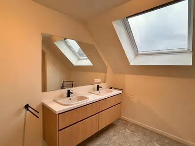 a bathroom with two sinks and a large mirror at Spacious 3-Floor Holiday Home for 8 Guests in Bree