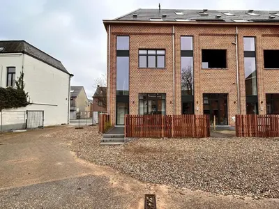 a brick house with a fence in front of it at Spacious 3-Floor Holiday Home for 8 Guests in Bree