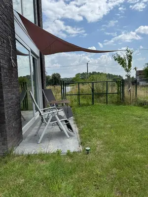 a chair sitting on a porch with an umbrella at Dukes View -explore Haspengouw & surrounding towns in Zoutleeuw