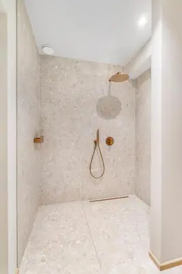 a bathroom with a shower with a stone wall at De Kompanie in Alken