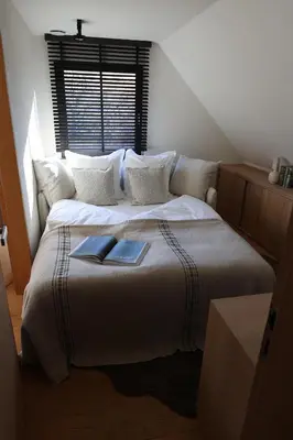 a bedroom with a bed with a book on it at Homestorys Nature Resort - Wood Lounge in Eupen