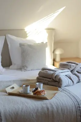 a tray with two cups of coffee and towels on a bed at Homestorys Nature Resort - Wood Lounge in Eupen