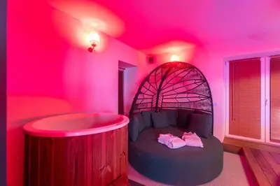 a room with a tub in a pink room at Temple Torii in Crisnée