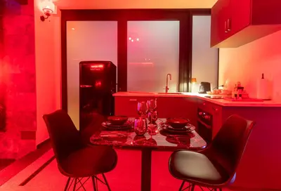 a kitchen with a table and chairs and a refrigerator at Temple Torii in Crisnée