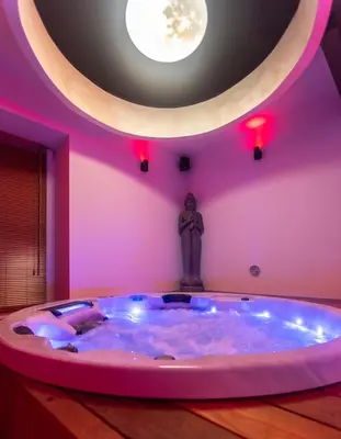 a large hot tub in a pink room with a statue at Temple Torii in Crisnée