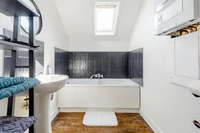 a bathroom with a white tub and a sink at L'appartement Casquette in Liège