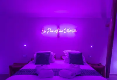 a purple room with a bed with a sign that reads i want to be violet at L'Améthyste in Crisnée