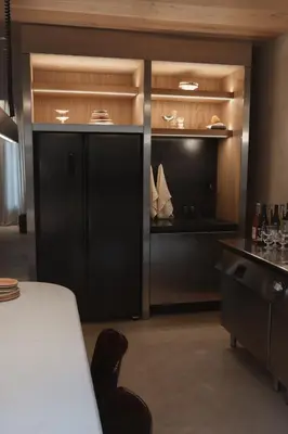 a room with a black refrigerator and a table with wine glasses at number nine house in Hasselt