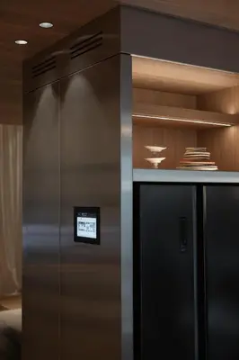 a stainless steel refrigerator in a room with wooden walls at number nine house in Hasselt