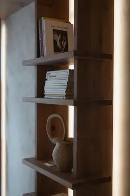 a book shelf with a vase and books on it at number nine house in Hasselt