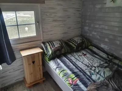 a small bed in a room with a window at Lanklaar Chalet with Garden in Lanklaar
