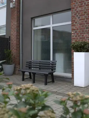 a bench sitting in front of a window at Casa Verde in Maasmechelen