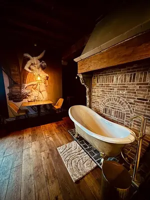 a bathroom with a bath tub next to a brick wall at 'T Rood Kasteel in Hasselt