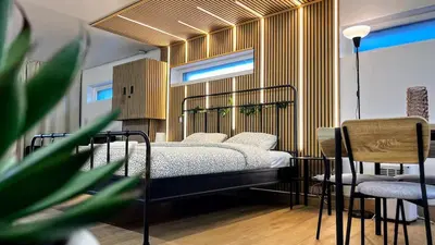 a bedroom with a bed and two chairs at Chez Margueritte, Cosy, Jacuzzi & Parking Facile in Liège