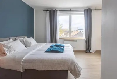 a bedroom with a large bed with a window at Moni 2D Residence in Seraing
