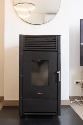 a black fireplace in a room with a mirror at Moni 2D Residence in Seraing