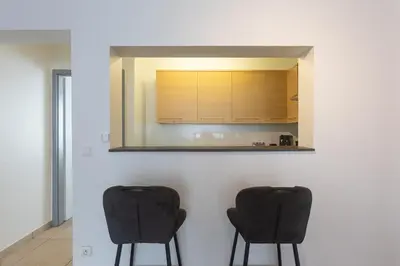 two black chairs in a kitchen with a mirror at Moni 2G Residence in Seraing