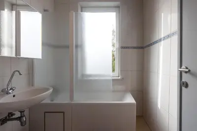 a white bathroom with a sink and a shower at Moni 2G Residence in Seraing