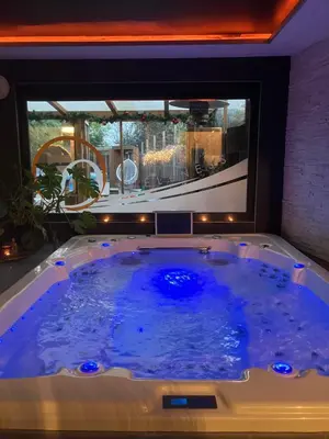 a jacuzzi tub in a room with a window at Duplex 7 avec Spa Privé in Herstal