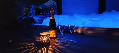 a bottle of wine and two wine glasses on a table at Duplex 7 avec Spa Privé in Herstal