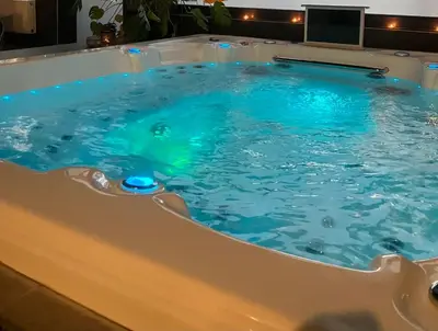 a jacuzzi tub in a hotel with blue water at Duplex 7 avec Spa Privé in Herstal