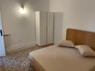 a bedroom with a large bed and a cabinet at chez zakk in Seraing