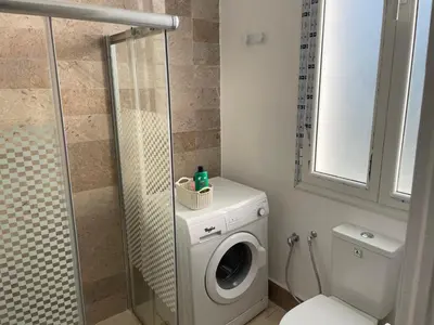 a bathroom with a washing machine and a toilet at chez zakk in Seraing