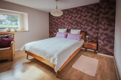 a bedroom with a large bed with pink pillows at Im Prummehuck in Raeren