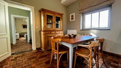 a kitchen with a wooden table and chairs at Hoefke Voort - Familievakantie midden in de natuur