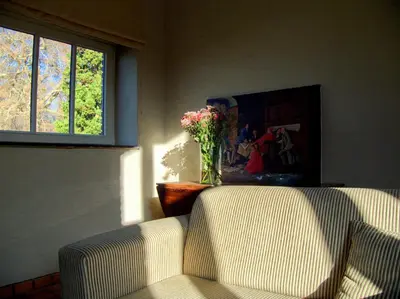 a living room with two chairs and a vase of flowers at Hoefke Voort - Familievakantie midden in de natuur