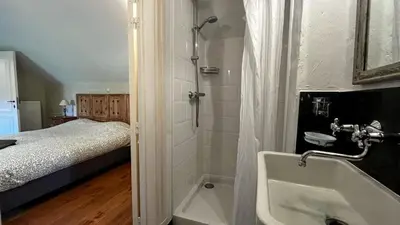 a bathroom with a shower and a tub and a bed at Hoefke Voort - Familievakantie midden in de natuur