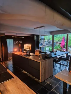 a kitchen with a counter and a table with chairs at Villa Marvin in Soumagne