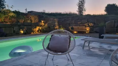 a wicker chair sitting next to a swimming pool at Villa Marvin in Soumagne