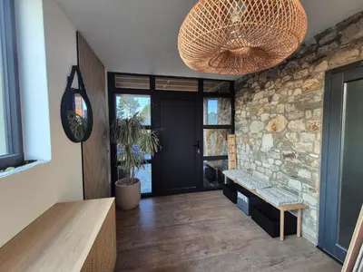 a living room with a stone wall and a ceiling at Villa Marvin in Soumagne