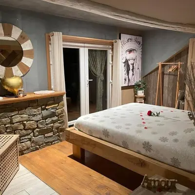 a bedroom with a large bed and a stone wall at Apartment Design Suite in Jehanster
