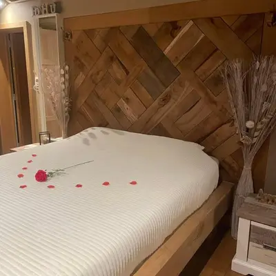 a white bed with red rose pedals on it at Apartment Design Suite in Jehanster